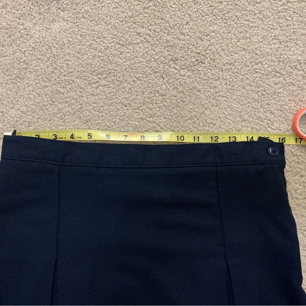 Navy blue pleated skirt with adjustable waist.